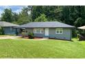 Charming gray home features a lush, well-manicured lawn and welcoming entrance with tasteful landscaping at 2107 Garden Cir, Decatur, GA 30032