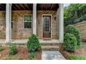 Charming home entrance with a glass paneled front door and lovely landscaping at 747 Topsail Ln, Alpharetta, GA 30005