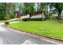 View of the brick ranch home with a lush green lawn on a sunny day at 900 Fleetwood Cir, Atlanta, GA 30311