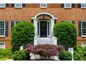 Close-up of the inviting front door, enhanced with lush landscaping and elegant architectural details at 10645 Tuxford Dr, Alpharetta, GA 30022