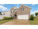 Classic brick home with attached garage, complemented by a lush green lawn and mature landscaping at 1504 Lemon Balm Ct, Lawrenceville, GA 30045