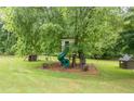 Backyard play area including custom tree house, slide, and playhouse at 4067 Mason Creek Rd, Winston, GA 30187