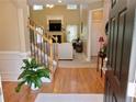 Welcoming foyer with hardwood floors, staircase with iron railing, and a view into the bright and spacious living room at 4895 Smokestone Dr, Douglasville, GA 30135