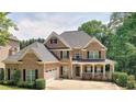 Charming brick home featuring black shutters, covered porch and a well-maintained lawn and landscape at 4895 Smokestone Dr, Douglasville, GA 30135