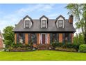 Inviting brick home with dormer windows, complemented by a well-manicured lawn and front yard at 2747 Livsey Trl, Tucker, GA 30084