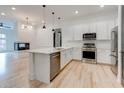 Well-equipped kitchen with stainless steel appliances, white cabinets, and an island open to the living area with a fireplace at 625 Piedmont Ne Ave # 2004, Atlanta, GA 30308