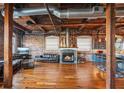 Open-concept living room with exposed brick, hardwood floors, fireplace, and industrial-style ceiling at 490 Marietta St Nw # 307, Atlanta, GA 30313