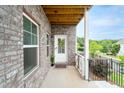 Cozy covered porch featuring brick accents, a white door, and manicured landscaping at 831 Corsiglia Farm Flts, Marietta, GA 30060