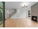 Bright, open-concept living room with a fireplace, hardwood floors, and staircase at 1186A Francis Nw St, Atlanta, GA 30318