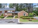 Well-maintained townhouse with brick accents, mature trees, and landscaped grounds at 49 Country Ct, Alpharetta, GA 30005