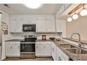 Modern kitchen with stainless steel appliances, granite countertops, and white cabinets and hardware at 6035 Wintergreen Rd, Norcross, GA 30093