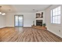 Spacious living area featuring a cozy fireplace, laminate floors, and sliding doors to the outside patio at 6035 Wintergreen Rd, Norcross, GA 30093