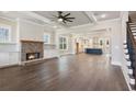 Spacious living room with hardwood floors, brick fireplace, and view into the kitchen at 95 Old Town Rd, Dacula, GA 30019