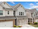 Lovely townhome showcases brick and siding facade, complimented by a two-car garage and manicured landscaping at 109 Camden Park Dr, Woodstock, GA 30188
