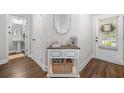 Bright entryway with hardwood floors, a console table, a decorative mirror, and a view into the powder room at 109 Camden Park Dr, Woodstock, GA 30188