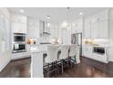 Modern kitchen featuring white cabinets, stainless steel appliances, and a breakfast bar at 3330 Carswell Bnd, Cumming, GA 30028