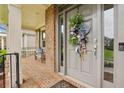 Inviting front porch with brick flooring, decorative wreath, and bench seating, offering a cozy entrance at 3665 Pennington Rd, Cumming, GA 30041