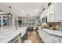 Bright kitchen featuring marble countertops, white cabinets, stainless steel appliances, and a breakfast nook at 3665 Pennington Rd, Cumming, GA 30041