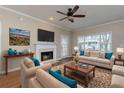 Cozy living room with a fireplace, neutral color scheme, and a ceiling fan at 8020 Woodland Ln, Alpharetta, GA 30009