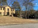 Residential home nestled in a wooded neighborhood with a well-kept lawn and landscaping at 7592 Watson Kaye, Stone Mountain, GA 30087