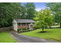 Well-maintained brick home featuring a driveway, manicured lawn, and lush green trees at 2640 Spring Se Dr, Smyrna, GA 30080