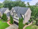 An elegant home with a lush, well-maintained lawn, featuring a two-car garage and manicured shrubs at 7060 Summit Ridge Chase, Cumming, GA 30041