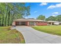 Long driveway leading to a brick home with an attached carport, showcasing curb appeal at 191 Pine Ne St, Fairburn, GA 30213