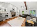 Bright living room featuring hardwood floors, a stone fireplace, vaulted ceiling, and a comfortable gray sectional at 2020 New Kemp Rd, Marietta, GA 30066