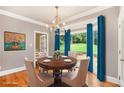 Elegant dining room featuring hardwood floors, large window, chandelier, and designer window treatments at 386 Link Rd, Alpharetta, GA 30022