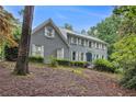 Charming two-story brick home with gray siding, white shutters, and mature landscaping during the day at 386 Link Rd, Alpharetta, GA 30022
