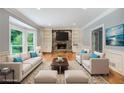 Bright living room with stone fireplace, built-in bookshelves, hardwood floors, and large bay windows at 386 Link Rd, Alpharetta, GA 30022