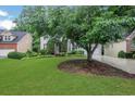 View of the home's exterior with a large tree in the front yard, showcasing a serene and lush landscape at 11280 Brookhollow Trl, Alpharetta, GA 30022