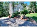 Home featuring lush landscaping and a long driveway at 1875 Skidmore Cir, Lawrenceville, GA 30044