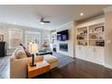 Bright living room featuring a fireplace, built-in shelving, hardwood floors, and large windows at 4104 Townsend Ln, Dunwoody, GA 30346