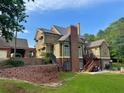 Rear exterior view of a two-story home featuring a brick retaining wall and wooden patio at 1695 Whitley Rd, Dacula, GA 30019
