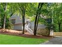 Charming home with stone accents and lush greenery, featuring a stairway leading to the front door at 3726 Scotts Mill Run, Peachtree Corners, GA 30096
