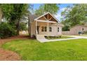 Quaint home featuring a lovely front lawn, welcoming porch, and private driveway at 1036 Dell Se Ave, Smyrna, GA 30080
