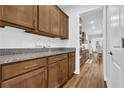 Walk-in pantry with granite countertops, warm brown cabinetry, and an open doorway at 307 Ernest Ave, Peachtree City, GA 30269