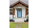 Close-up of a beautiful blue front door with decorative accents, and a well-kept front yard at 3412 Orchard St, Atlanta, GA 30354