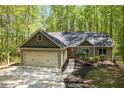 Beautiful home exterior featuring a two-car garage, landscaped yard, and inviting walkway at 191 Orchard Dr, Canton, GA 30115