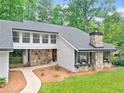 View of the exterior highlighting stonework, windows, and landscaping at 2435 Roxburgh Dr, Roswell, GA 30076