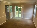 Dining room area with a chandelier and sliding glass doors leading to a wooden deck at 4963 Windsor Downs Ln, Decatur, GA 30035