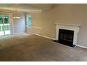 Spacious living room featuring a fireplace, neutral carpet, and sliding glass doors to a deck at 4963 Windsor Downs Ln, Decatur, GA 30035