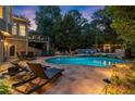 Stunning outdoor pool area with stone patio, lounge chairs, and lush greenery, perfect for relaxation at 979 Pathview Ct, Dacula, GA 30019