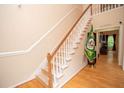 Elegant staircase with white banisters and hardwood floors adds a touch of sophistication to the home at 155 Redspire Ln, Fayetteville, GA 30215