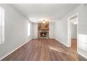 Living room with a stone fireplace, wood floors, and a view into another room at 3448 Great Meadows Ct, Lithonia, GA 30038