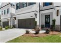 This townhome features a two-car garage, front door, and manicured landscape at 709 Dodd Ln # 165, Buford, GA 30518