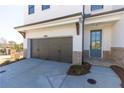 Exterior view showcasing a two-car garage and front entrance with brick and trim accents at 709 Dodd Ln # 165, Buford, GA 30518
