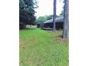 Large, level backyard featuring mature trees, a deck, and privacy fence at 5475 Morning Creek Cir, Atlanta, GA 30349