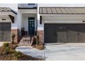 Inviting brick townhome featuring a covered front porch and two-car garage, exuding curb appeal at 706 Dodd Ln # 157, Buford, GA 30518